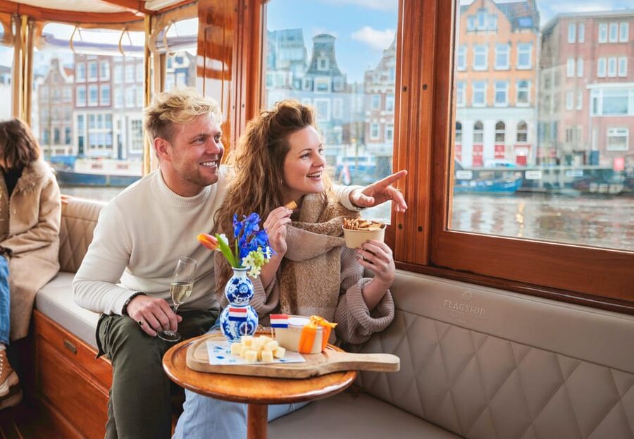 Amsterdam: Canal Cruise with Bubbles & Bites - Boarding a covered boat in central Amsterdam